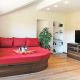 Entspannungszimmer mit rotem Sofa und TV - Woodstocker Tischlerei - Seefeld Leutasch